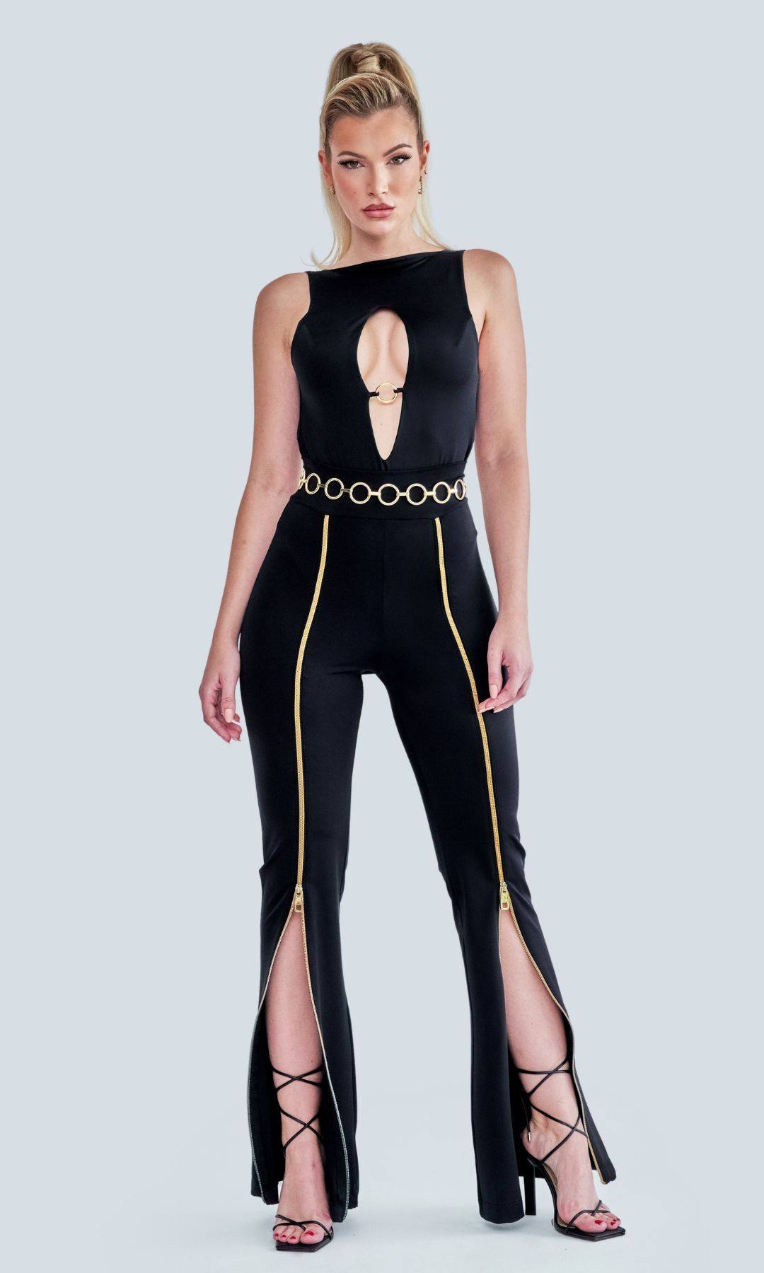 High-waisted black Zipnisa pants with golden zip detailing, shown in a sleek, fitted style, made from eco-friendly materials, worn with swimwear